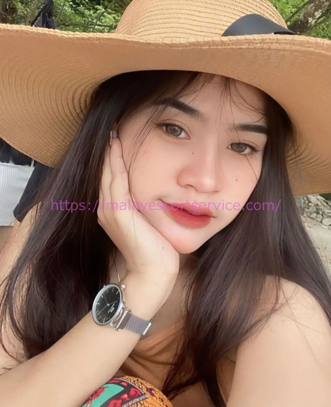 Young Malay woman wearing a sunhat and wristwatch.