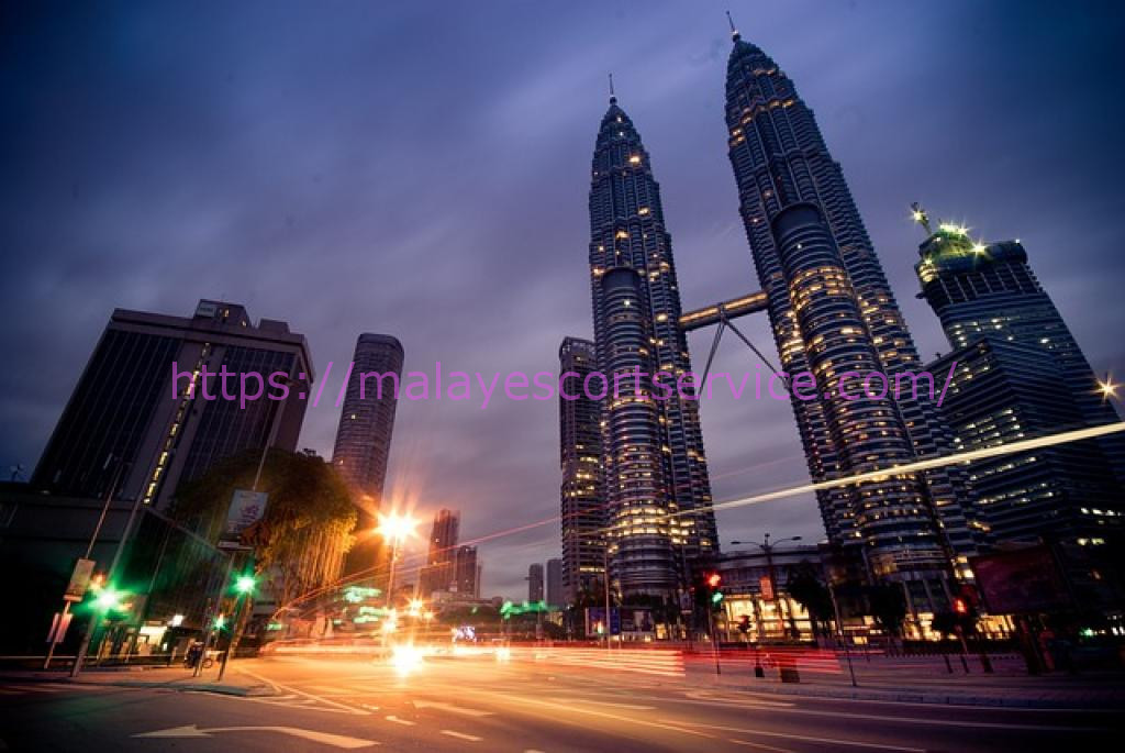 Night view of Kuala Lumpur's Petronas Twin Towers and city skyline.