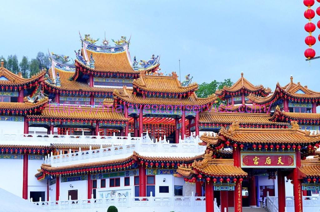 Ornate Chinese temple with red and gold roofs and lanterns. The main gate displays Chinese characters.