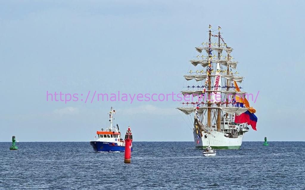 Tall ship sailing past a smaller vessel at sea