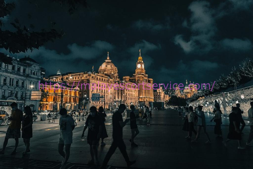 Night view of illuminated buildings and walking silhouettes in an urban street