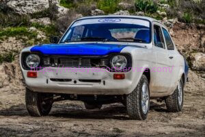 White Ford Escort rally car in off-road setting.